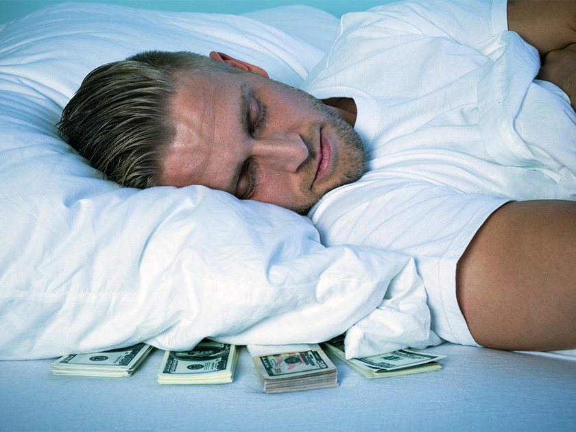 Взрослый мужчина с серьезным выражением лица, держит деньги, крупный план.