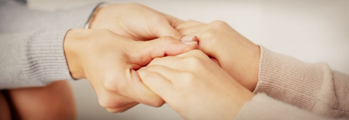 Фото человеческой руки, держащей руку младенца во время массажа запястья.