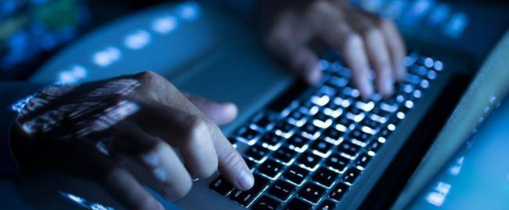 Ноутбук на столе с клавиатурой и другим компьютерным оборудованием.