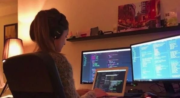 Человек работает за компьютером, монитор на заднем плане, электроника.