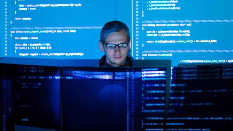 Мужчина на заднем плане экрана компьютера, обращенного к нему.