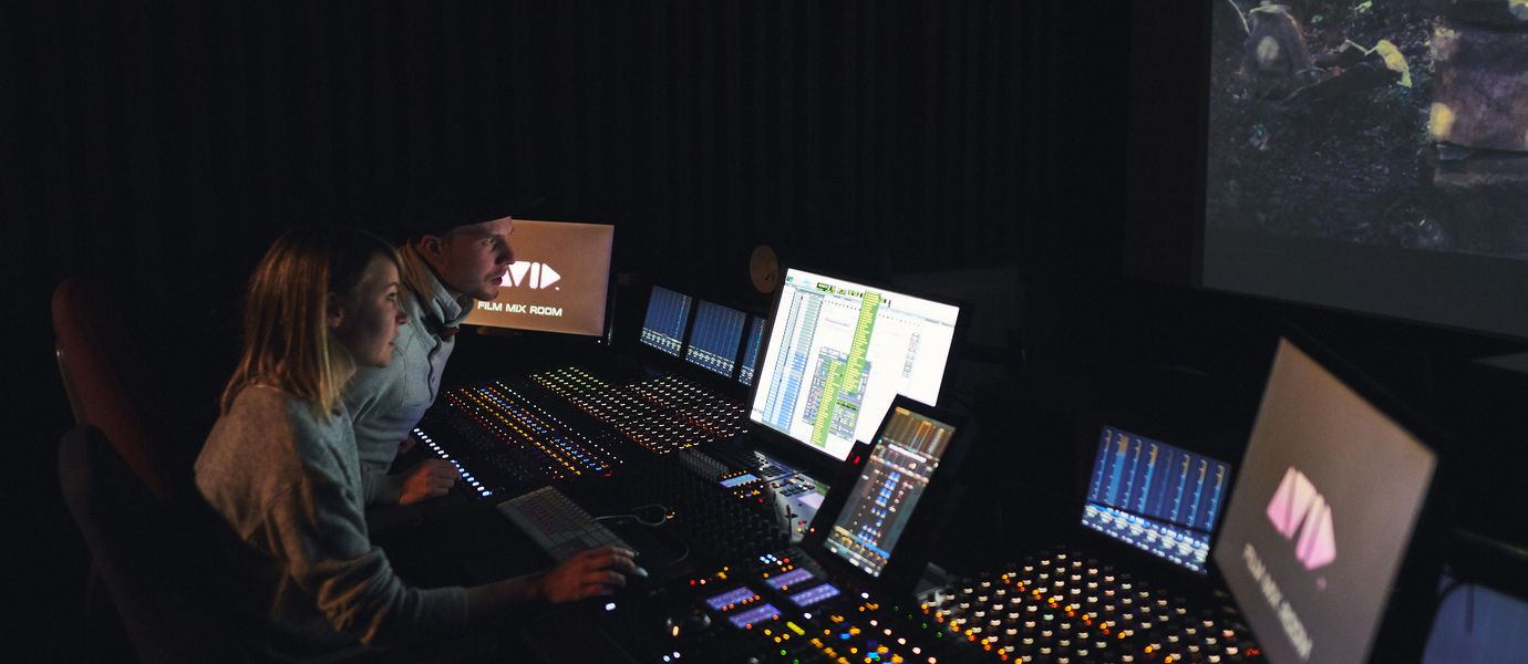 Компьютерная аппаратура и монитор в студии с лицом человека.