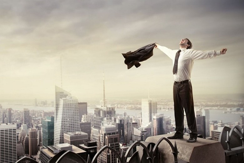 Городской пейзаж с высокими небоскрёбами, офисными зданиями и портретом мужчины.