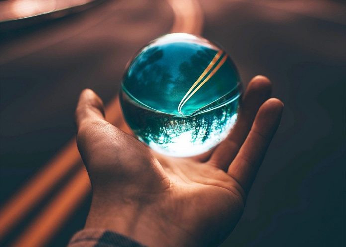 Сфера в руке человека, показывающего пальцем.