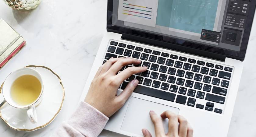 Ноутбук с клавиатурой и чашкой на фоне, электроника, компьютерное железо.