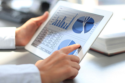 Человек работает на планшетном компьютере с электроникой и компьютерным оборудованием.