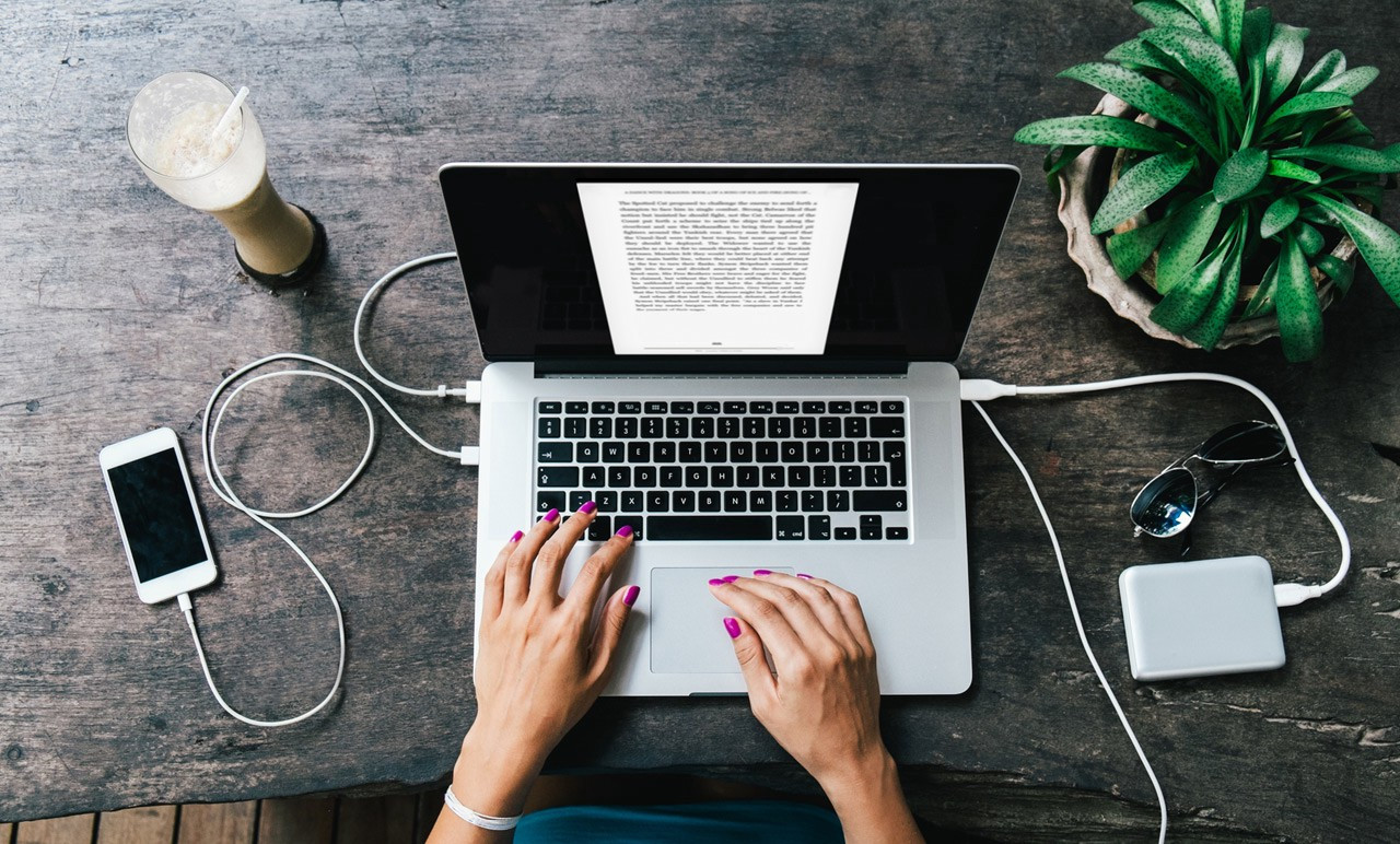 Электроника: ноутбук, ПК, растение, клавиатура, мобильный телефон на рабочем столе.