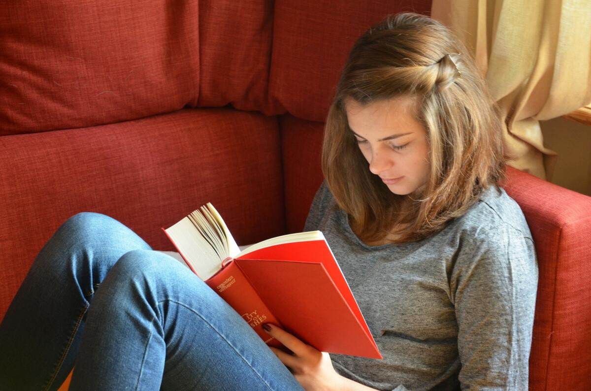 Человек читает книгу, лицо с книгой, джинсы, публикация на книге.