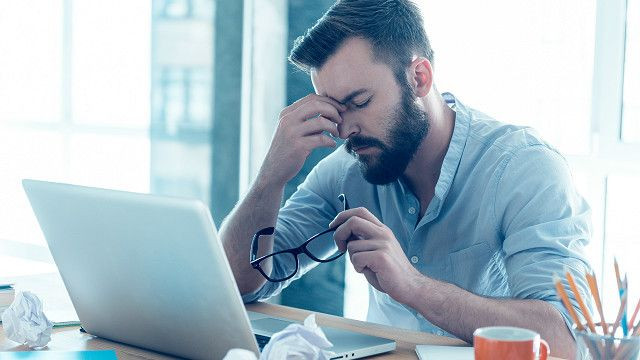 Человек с грустным лицом перед ноутбуком и компьютером, электроника.