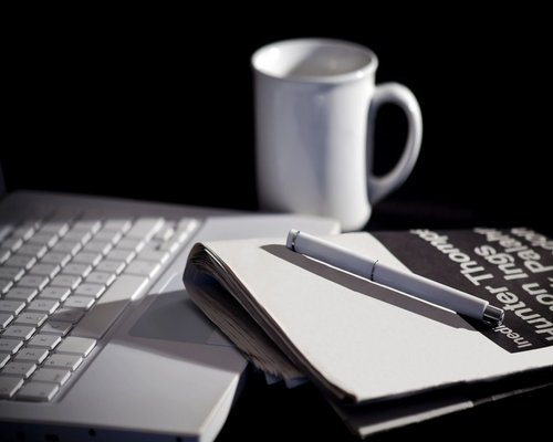 Ноутбук на столе с клавиатурой, ручкой и чашкой, электроника, компьютерные комплектующие.