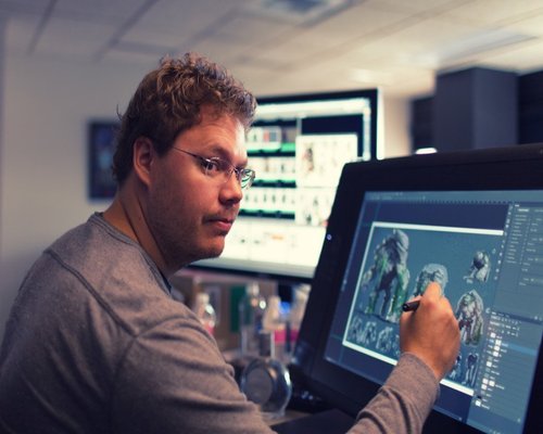 Взрослый мужчина смотрит на монитор компьютера - электроника и аппаратное обеспечение.