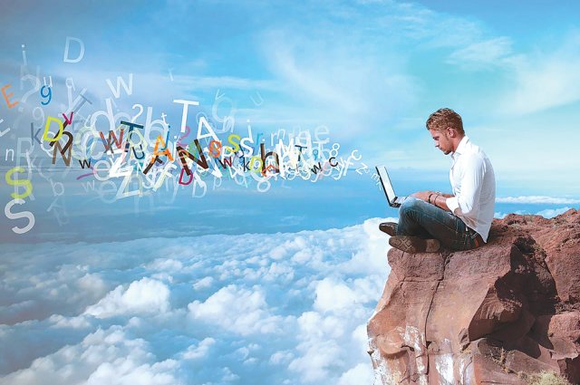 Фотография человека, читающего на скале в природе с компьютером.