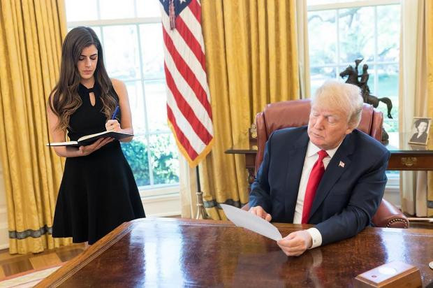 "An adult female holding a knife indoors, facing a male with a weapon."