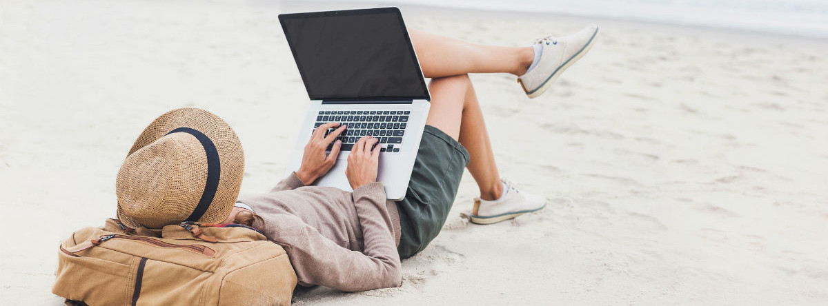 Женщина в шляпе и обуви сидит за компьютером лэптопа.