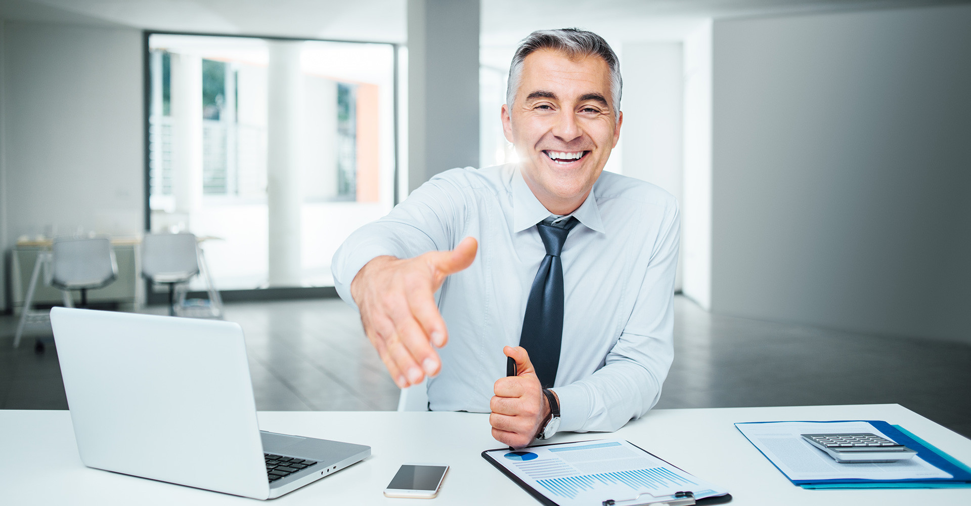 Исполнитель в деловом костюме с ноутбуком, взгляд на экран, мужчина.