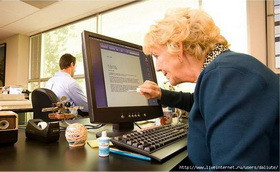 Мужчина-взрослый смотрит на монитор ПК за столом с компьютерной техникой.